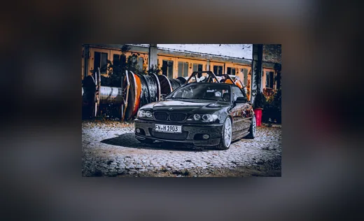Dunkler BMW vor einer Werkhalle