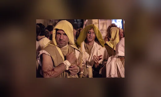 Teilnehmer einer Prozession in Kutten, Nachtaufnahme